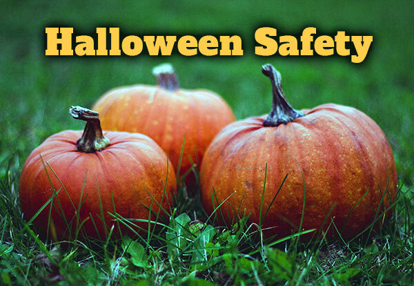 Halloween Safety text over three pumpkins sitting in the grass.